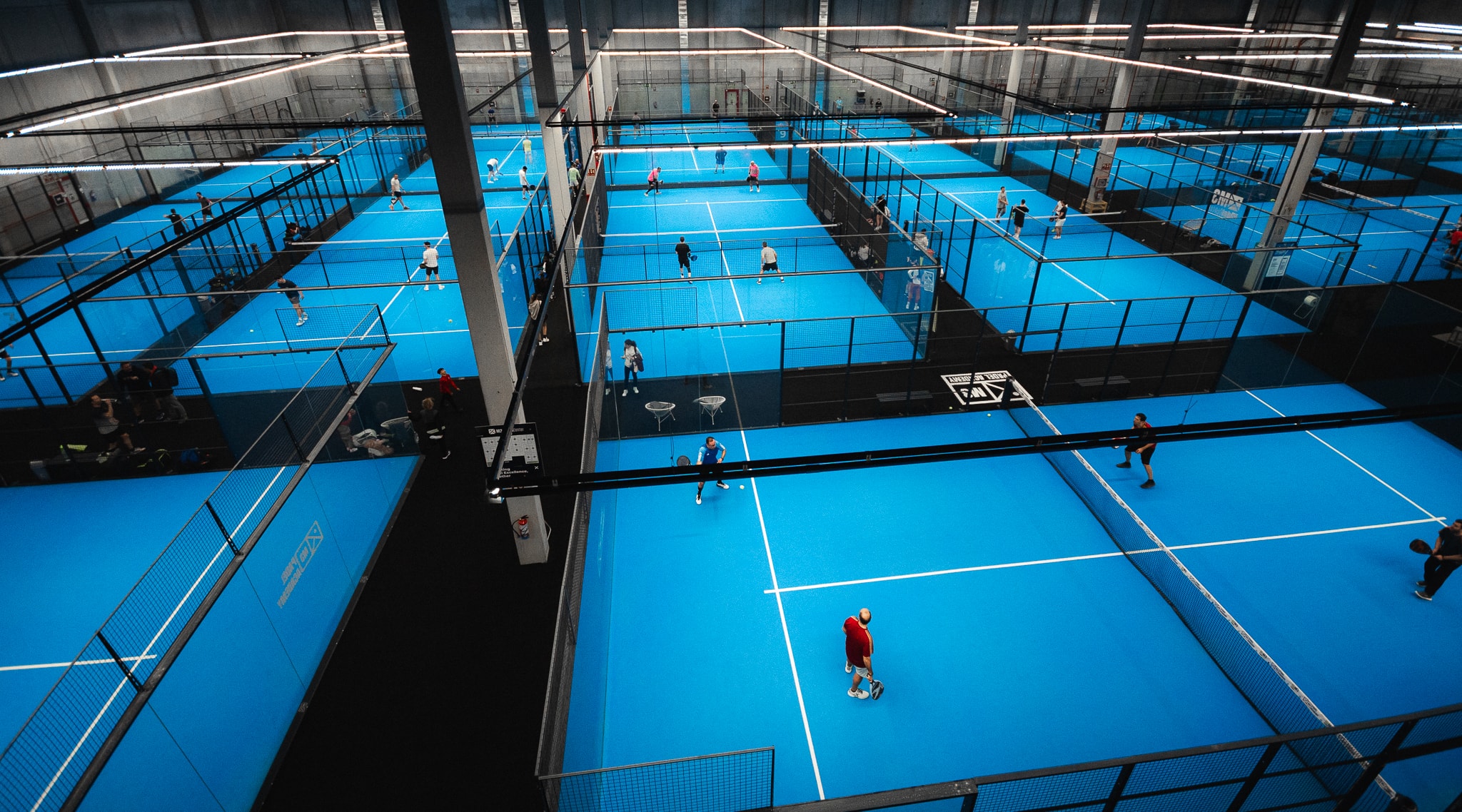 Rows of blue indoor padel courts at M3 Padel Academy in Madrid, seen from above